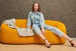 Frau-in-Jeans-Jumpsuit-auf-einer-Couch